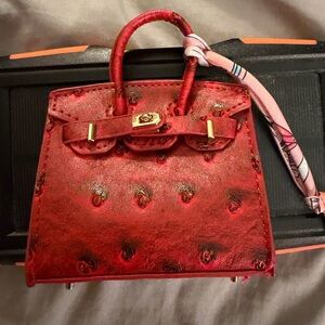 This is a mini faux leather bag charm with scarf. Perfect for earbuds.